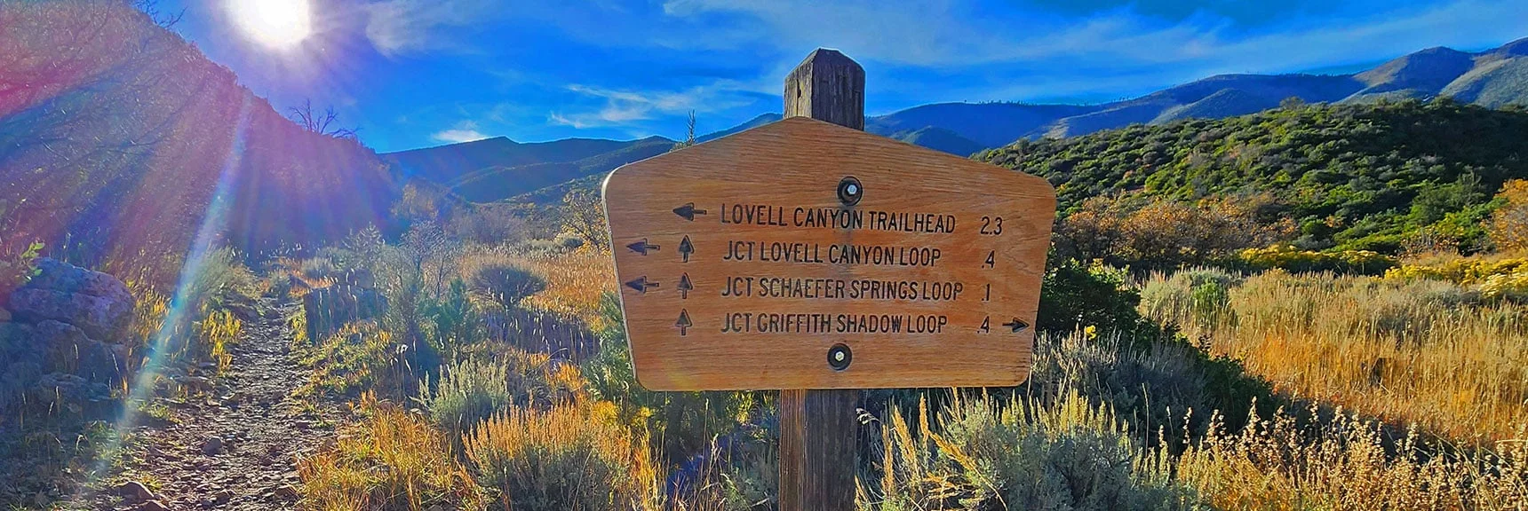 Now on West Side of Canyon. Trail Sign Lists Choices Here. Heading for Trailhead. | Griffith Shadow Loop | Lovell Canyon, Nevada